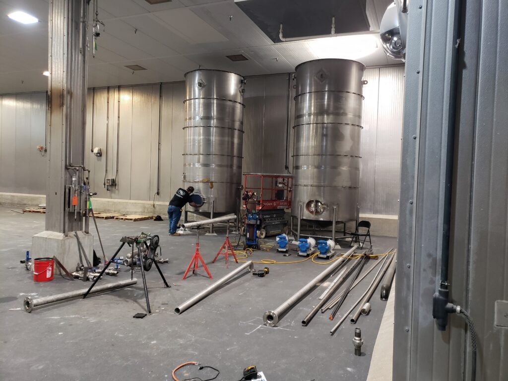 A dense arrangement of pipes, metal conduits, and frameworks, suspended from the ceiling.