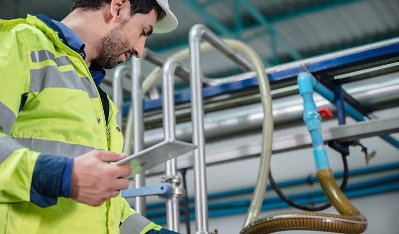 man in hi-vis jacket maintaining process piping