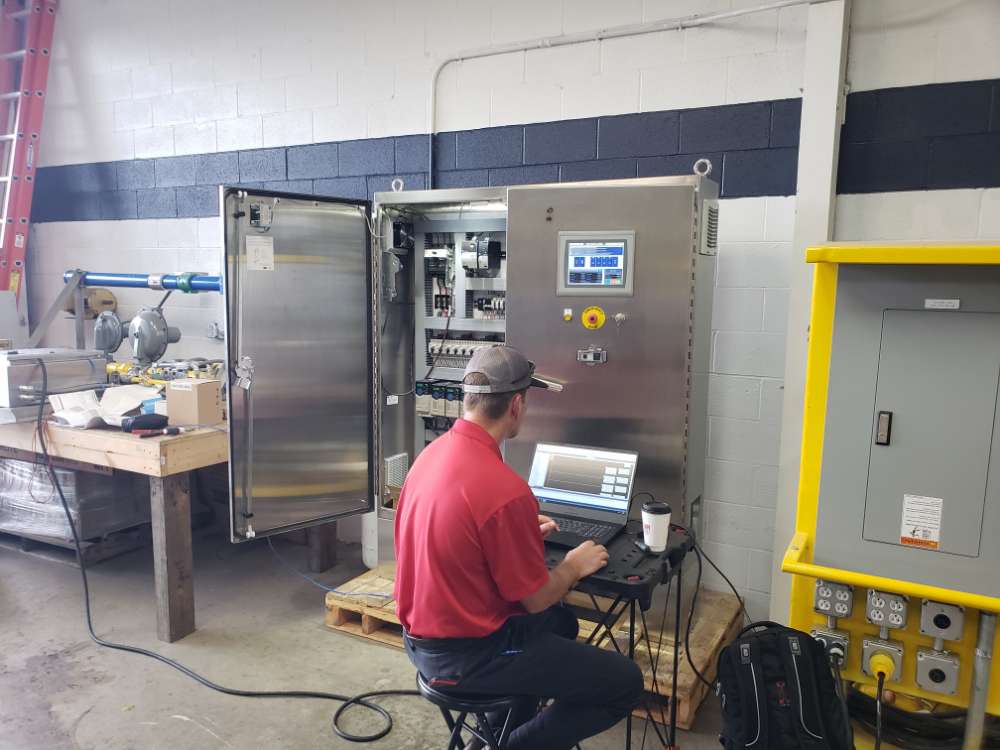 PEC electrician working at electrical control panel